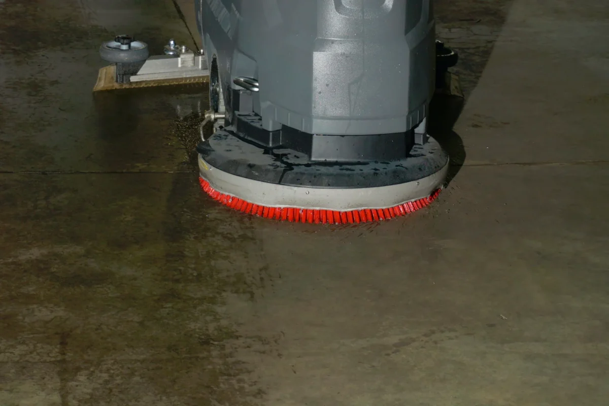 Scrubber-dryer brush cleaning a concrete floor