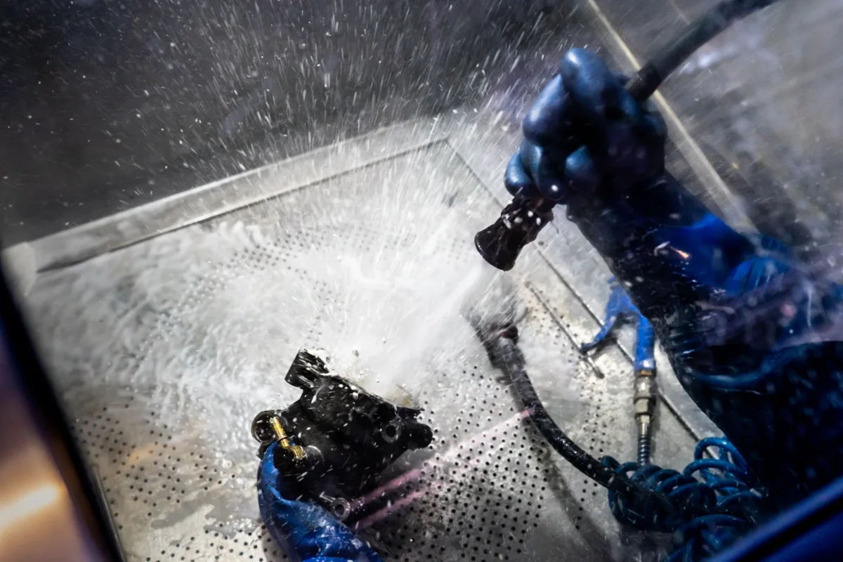 Industrial water-jet cleaning viewed through a protective screen