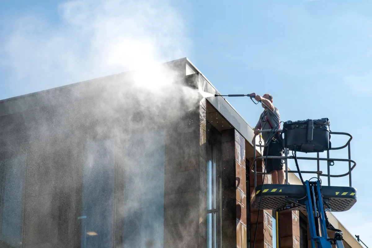 Worker cleaning a building façade from an elevated work platform